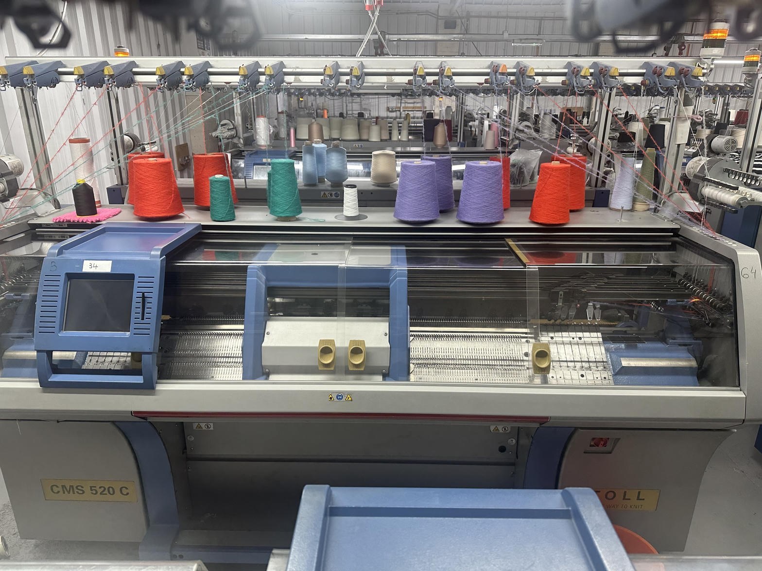 Stoll flat-bed knitting machine with yarn feeders