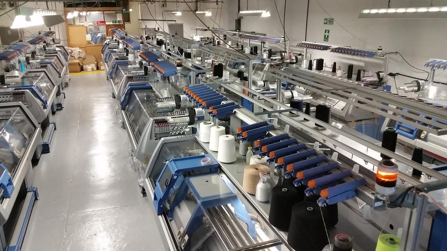 Row of computerized flat knitting machines